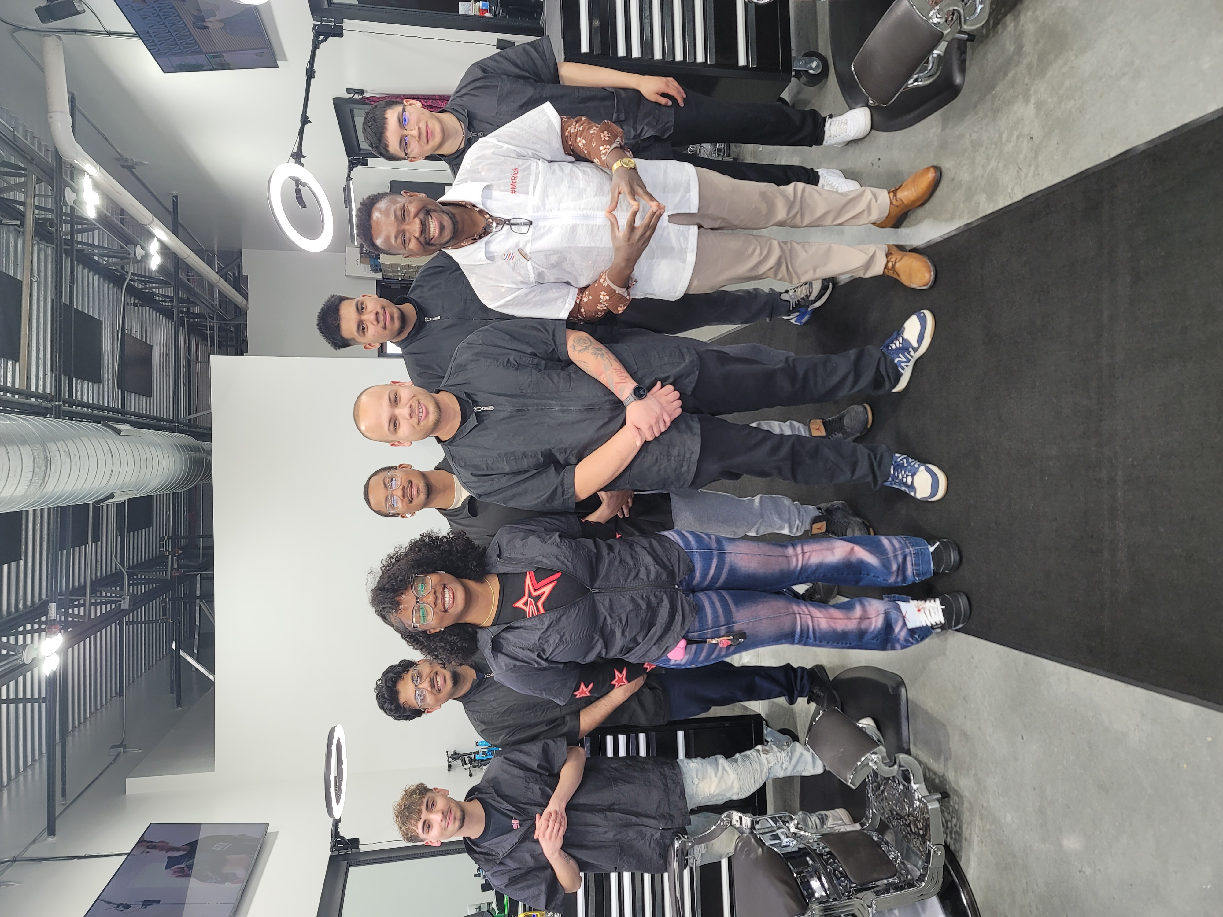 Marvelous Barber School alumni lined up with Mr. Rick in the clinic after final evaluations.